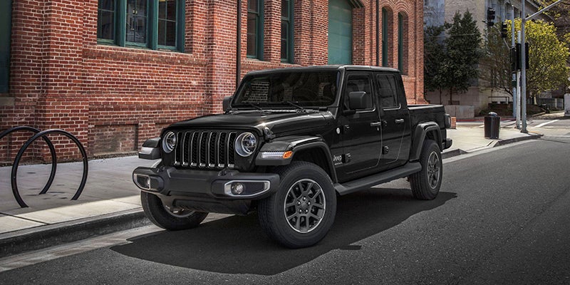 A photo of a black 2024 Jeep Gladiator parked on a street