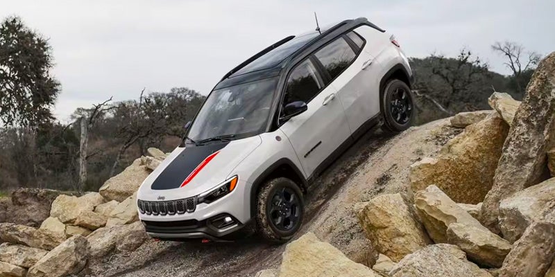 A 2024 Jeep Compass driving down a steep hill