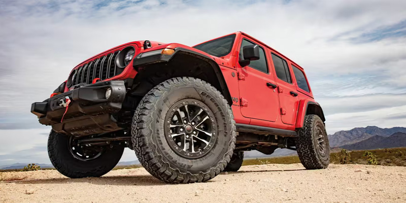 A photo of a red 2025 Jeep Wrangler, focused on it's tire