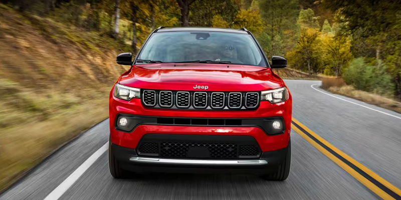 The front grille of a red 2025 Jeep Compass